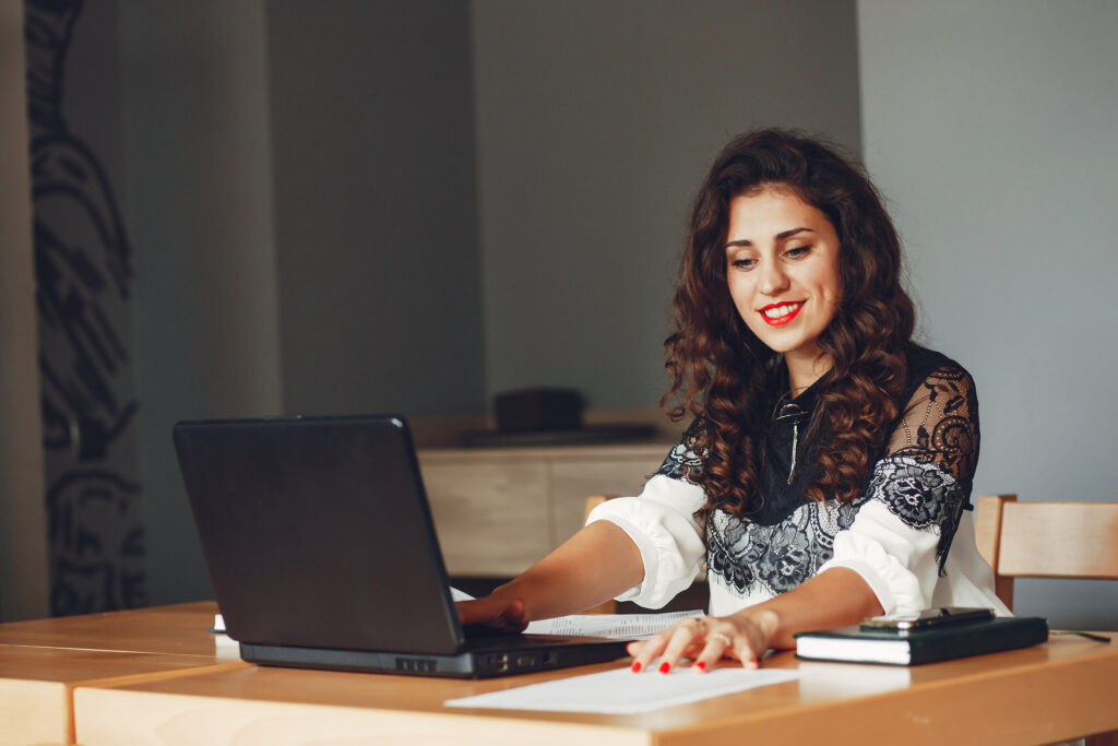 A woman working on laptop for Closed Captioning Services to connect the world