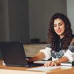 A woman working on laptop for Closed Captioning Services to connect the world