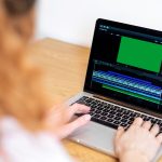 Young content creator girl editing video on her laptop. Working from home