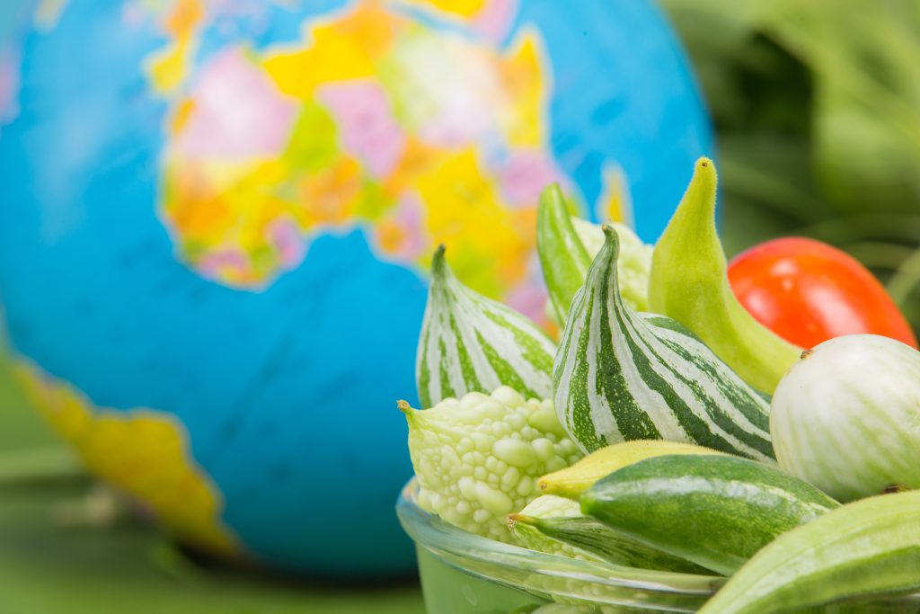 World food day ,Many vegetables are in a bowl with globes placed near the green banana leaves.