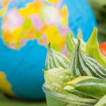 World food day ,Many vegetables are in a bowl with globes placed near the green banana leaves.