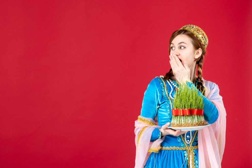 Portrait of azeri woman in traditional dress with semeni on red