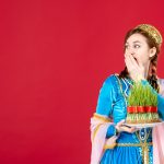 Portrait of azeri woman in traditional dress with semeni on red