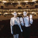 Portrait of female and male mime artist standing on stage