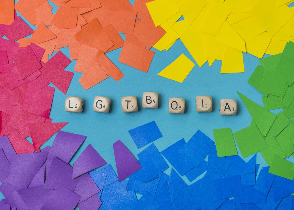 LGBTQIA word of cubes and heaps of paper in gay colors