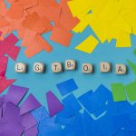 LGBTQIA word of cubes and heaps of paper in gay colors