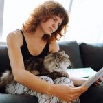 Pet owner reading detailed care instructions while gently holding their dog, demonstrating trusted pawprint care guidance