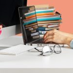 Person organizing and sorting documents and files on desk before sending them for professional typing services