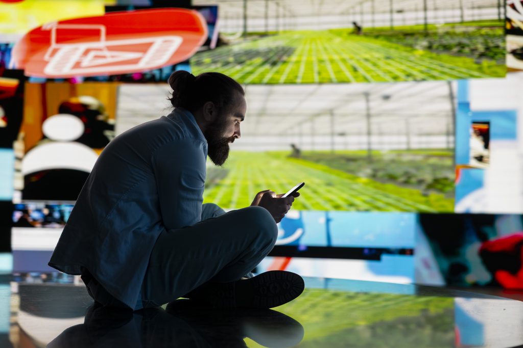 Stressed individual obsessively overuses his mobile phone social platforms