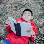 Cheerful Little Boy Reading Book