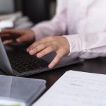 Smiley girl using her laptop keyboard