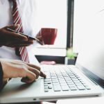 Business team analyzing income charts and graphs with modern laptop computer.