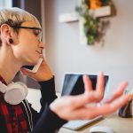 Person using assistive communication device with translation symbols helping world listen closer to fading voice