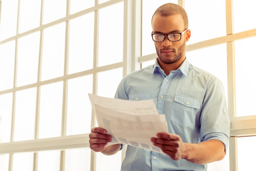Worker carefully reading clear employee rights document while complex legal papers remain unreadable on desk
