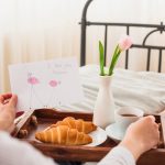 A mother's hands arranging family birth certificates on a kitchen table, with a Bronx street visible through the window - Real Story: A Bronx featured image