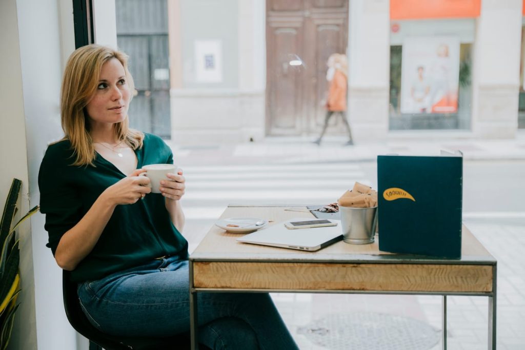 A customer at a reception desk handing over a folder of French university transcripts, with a Midtown street view through the window - Real Story: A Walk-In featured image