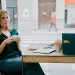 A customer at a reception desk handing over a folder of French university transcripts, with a Midtown street view through the window - Real Story: A Walk-In featured image