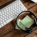 A desk with over-ear headphones beside a laptop showing a time-coded transcript page with speaker labels - Real Story: Eighteen Hours featured image