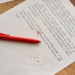 A handwritten legal draft covered in margin corrections lying beside a cleanly typed page on a desk - Real Story: Handwritten Estate featured image