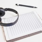 A desk with headphones, a waveform on screen and a printed speaker list marked with timestamps - Real Story: Six Audio featured image