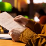 Two Spanish-language personal documents on a desk, one photographed sharply and one blurred, beside a typed English translation - Real Story: Two Spanish featured image