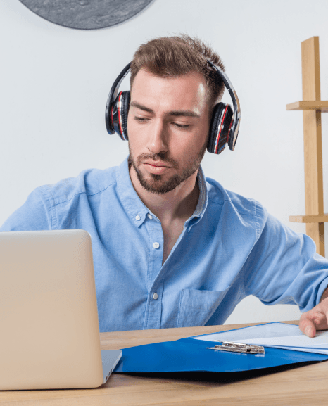 Wearing headphones, a grad student reviews long recordings while high-quality dissertation transcription services draft text.
